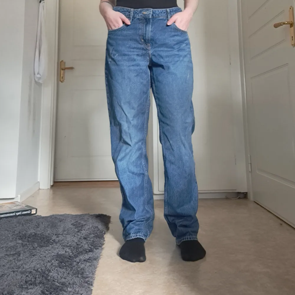 Jeans från H&M i straight fit. Blå med slitningar vid fickorna på framsidan. I fint skick. Storlek 44.. Jeans & Byxor.
