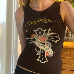 Ed Hardy topp - Snygg brunt linne från Ed Hardy. Några paljetter/diamanter på tröjan har åkt av men annars i bra kvalitet🫶🏼