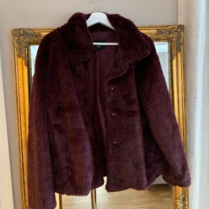 Lila pälsjacka  - Lila pälsjacka, köpt på Lindex för några år sedan, men har knappt använt den. I bra skick.  