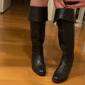 Svarta stövlar - Säljer mina skit snygga svarta stövlar som är köpte second hand för 250kr men i väldigt bra skick!!! Inga defekter och man kan ha de på två olika sätt (se sista bilden). Oklart vilken storlek men skulle säga att de passar storlek 40-41! ❤️🙏
