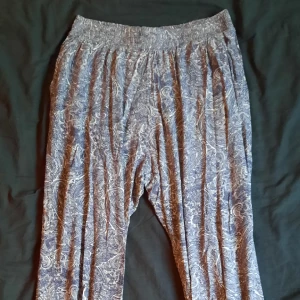 Mjukisbyxor med orientaliskt mönster - Tunna byxor med ljusblått orientaliskt mönster. Resor i midjan och längst ner på byxbenen. Har fickor. Supermysiga som pyjamasbyxor!