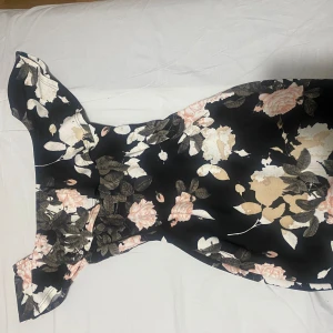 Blomnig off shoulder klänning - Klänningen är använd en två gånger. Den sitter väldigt fint runt axlarna med volangerna samt figurframhävande form på klänningen