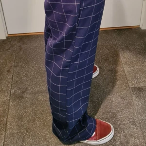 Rutiga pleated trousers - Mörkblå pleated trousers med rutigt mönster på från Monki, straight leg fit. Fint skick och sitter bra men de är lite långa för mig. Jag är 170cm och de är i storlek 38 / S/M😊