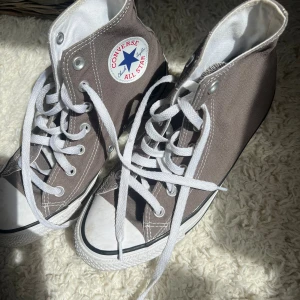Ljusbruna converse  - Fina ljusbruna converse skor i st 39! Dem är använda ett fåtal gånger. Jag skulle säga att färgen är mer åt den gråa nyansen men dem är ljusbruna! 