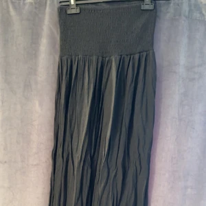 Lång kjol med smock - Lång kjol med smock i midjan. Hög slits i sidan. Aldrig använd. Storlek S. Säljer även en vit. Kolla gärna mina andra annonser :)