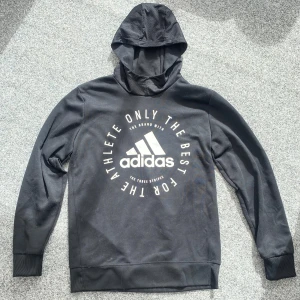 Svart hoodie - Säljer en svart hoodie från Adidas🤩Tror det är till för träning med tanke på det ”håliga” tyget runtom luvan & lite tunnare hoodie!! Strl.XL, men i barnstorlek så passar nog XS-S🙌🏻I bra använt skick. Deras märke är tryckt på framsidan🤗Kolla min profil