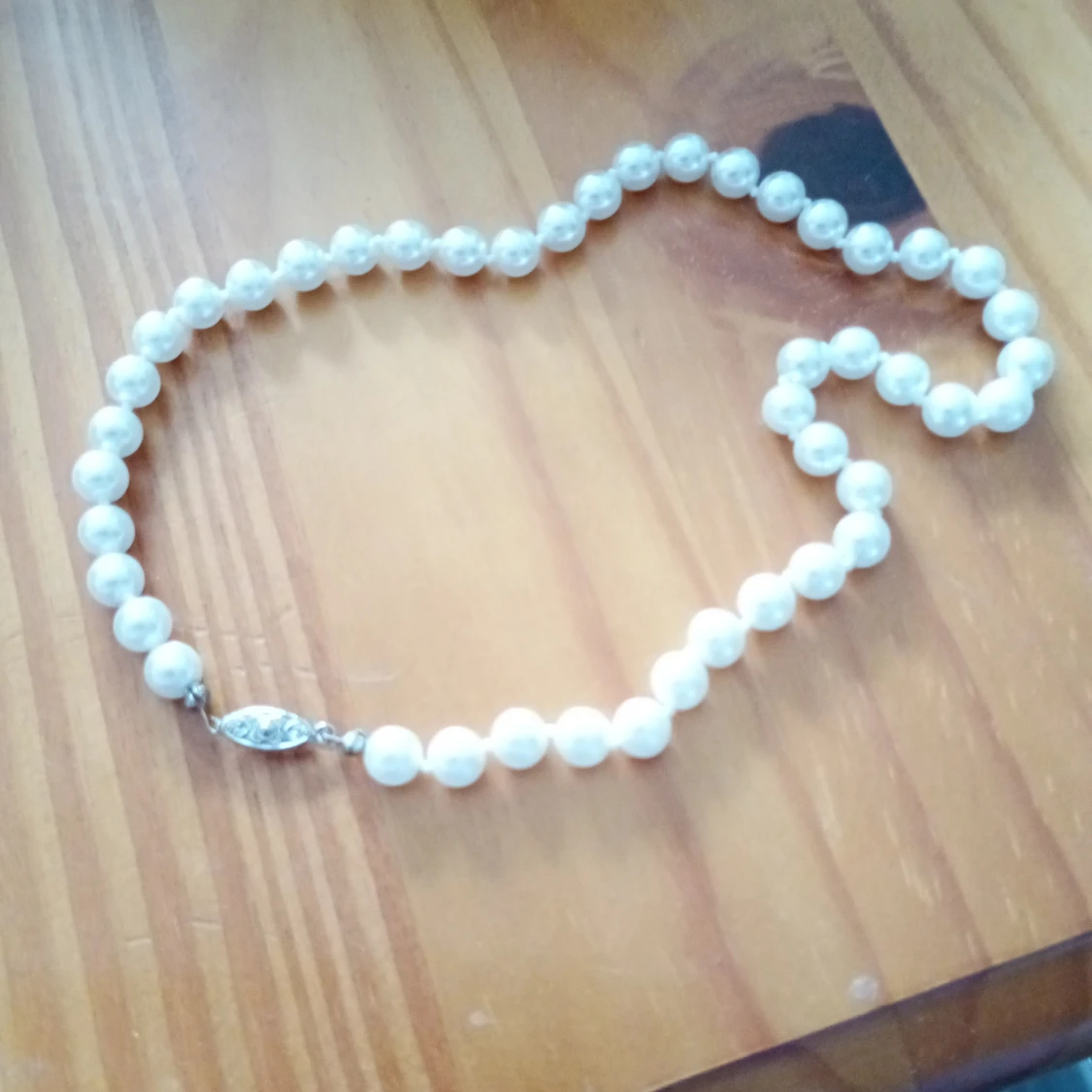 Pärlcollier med vita pärlor och lås.