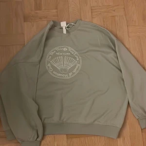Sweatshirt storlek XL - Pistagegrön sweatshirt med vitt tryck i storlek XL. Köpt på HM.