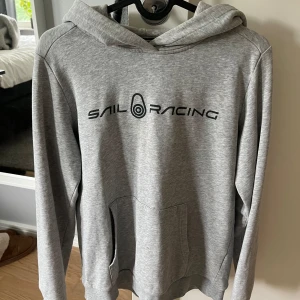 Hoddie  - Säljer min sailracing hoddie då den har blivit för liten. Som du ser på bilden har den små fläckar på magen som tyvärr inte går bort💗annars är den i väldigt bra skick. 