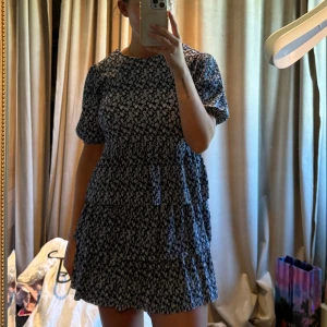 Blommig vit blå klänning - Snygg sommarklänning, med blommor på! Aldrig använd!