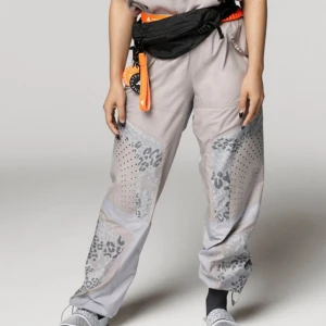 Adidas Stella McCartney byxor, XS - Byxorna har en elastisk midja med dragsko. De har fickor på sidorna och en liten ficka på baksidan. Byxorna har en rak passform och är gjorda av ett lätt och bekvämt material. Helt nya, enbart testade