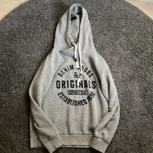 Jack and Jones hoodie  - En Jack and Jones hoodie i storleken S. Inga defekter utöver snörena som är spretiga. Detta kan man se på bilderna! Säljes då den inte längre kommer till användning. Tröjan är något liten i storleken!