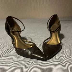Bruna stiletto klackar - Så snygga  stilettklackar med spetsig tå. De är gjorda i brunt skinn. De är använda men i hyfsat gott skick. Sörningen har ormmönster. Skriv gärna om du har fler frågor eller vill ha ytterligare bilder!