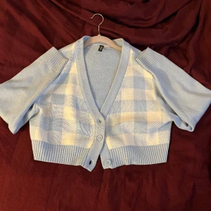 Croppad cardigan - En ljusblå croppad kofta med schack mönster på framsidan.  Frakten står köparen för ♥️
