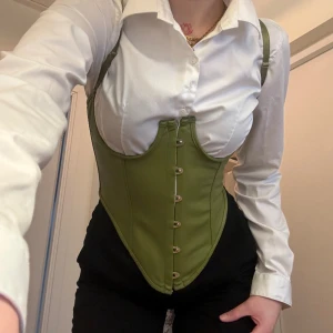 Korsett topp - Super snygg korsett top i grön faux läder, justerbar med band & axelband kan även tas av & sättas på igen. 