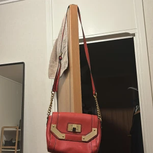 En röd väska - Den är 18cm lång, 24cm bredd