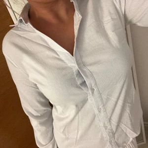 Skjorta  - Tunn, mjuk och Stretchig skjorta med vit, blå ränder från KOTON.  Storlek S