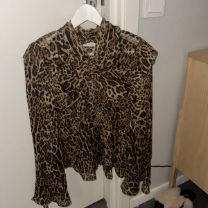 Topp  - Leopard topp med öppen rygg och högre krage. Aldrig använd. Storlek 34