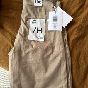 Chinos, beige, Selected Homme 30/34 - 10/10. Straight chinosbyxa, beige, W30/L34. Oanvända. Selected Homme. Nypris: 600kr. Köparen betalar frakt.