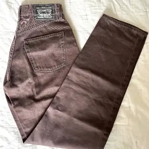Fantastiska bruna Levi’s jeans inköpta i USA på 90-talet. High waisted, straight leg! Nästan aldrig använda, Nyskick! Tyvärr något små i midjan för mig, sitter i övrigt väldigt bekvämt. Midja som XS/34 vilket jag uppskattar till W25. Längd 32. 