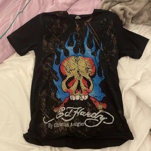 Edhardy t-shirt - den är köpt här på plick och den har ett litet hål längstner på tröjan men det märks inte när man väl har på sig den. Skriv för mer bilder!