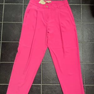 Rosa kostymbyxor  - Snygga kostymbyxor perfekta för sommaren. Två fungerande fickor på sidorna. Oanvända med prislapp.