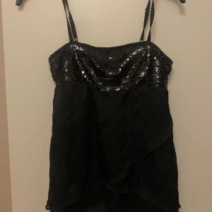 Fest blusa  - En svart blusa glittrig vid brösten 