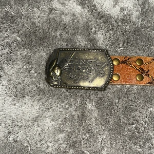 Ed Hardy bälte  - Fett ed Hardy bälte. 145 cm långt enligt han jag köpte den av. Kan skicka video där jag visar hela bältet tydligt då det är svårt å få in allt på tre bilder. Väldigt fint skick med minimala brister. 