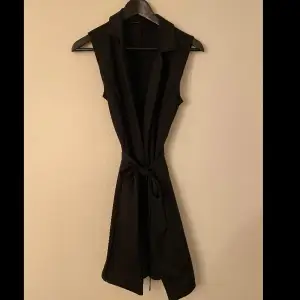 Svart kavajklänning från Nelly.com. Jag säljer en figursydd, stretchig och stilren klänning som passar till alla tillfällen. Den har ett band att knyta i midjan. Endast använd 1 gång. 