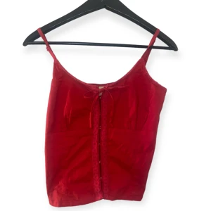 Rött linne  - Fint rött linne med korsettdetalj samt knytning❤️ Perfekt till sommaren eller som festlinne. Från märket Vero Moda men köpt second hand! 