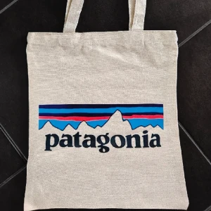 NY Patagonia tygväska / shoppingpåse - Helt ny och oanvänd! Ca 36x31 cm, tryck på ena sidan. Avhämtning eller skickas mot fraktkostnad, köpare står för frakt. Priset är fast. 
