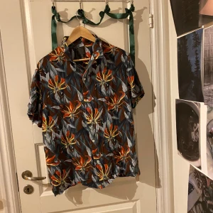 Kortärmad Sjorta  - Blommig kortärmad skjorta. Skön o luftig.