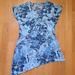 Blå paisley tröja - Superfin mönstrad blus. Mörk och ljusblå paisley topp, med asymmetrisk fåll. Tröjan är köpt på humana, men jag använde den typ 2 gånger. Storlek M.