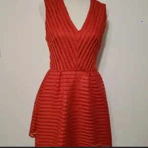 En fin röd klänning med är med en fin design från HM och är slevless