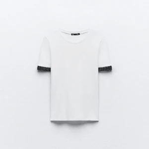 Zara t-shirt med accessoarer  - Säljer denna jätte fina tvist från zara, det är den så kallade ”t-shirt med accessoarer”. Jag säljer dock den med silver på armen inte guld. . Den med silver sälja inte längre. Aldrig använd då den vart förliten.  Nypris 229 Säljer för 130