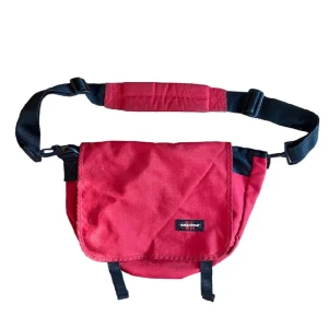 Vintage eastpak axelväska - Vintage röd eastpak axelväska. Riktig snygg och rymlig, går lätt att få en laptop osv. Mycket bra skick förutom lite missfärgning på baksidan vilket givetvis inte syns när man har på sig den. Skriv om det finns frågor eller funderingar!!