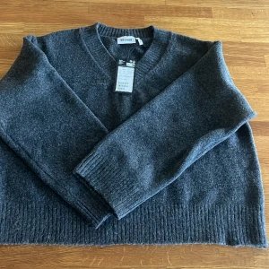 Mörkgrå oversized stickad tröja - Weekday ”Ergo V Neck Sweater” str S säljes. Oanvänd med prislappar kvar!