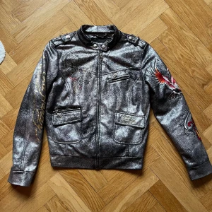 Ed Hardy skinnjacka (Limited Editon)  - Limited edition skinnjacka från Ed Hardy med diameter, broderier och coola detaljer på all metall. Storlek L men passar S-M 