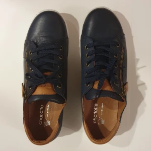 Sneakers (Charlotte of Sweden) stl 40 - "Charlotte of Sweden Sneaker Navy/Brandy" Storlek: 40 Skönt mjukt läder. Använda en enda gång. Nypris: 995 kr.  Pris: 200 kr. Möts upp i Stockholm för överlämning. 