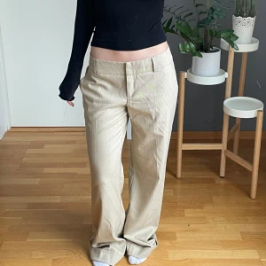 Lågmidjade kostymbyxor - Beiga lågmidjade randiga kostymbyxor i storlek 38, säljer då dem tyvärr är förstora för mig 🤩☺️ Helt nya med prislapp från vero Moda! Jag är 165 och dem är väldigt långa i benen