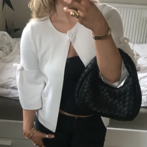 Trekvartsärmad kofta - Så söt vit kofta med trekvartsärm och söta rosetter, står ingen storlek men det är uppskattningsvis en S, kommer fler bilder med den på. Öppen för prisförslag 💕