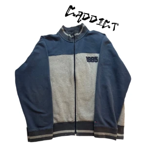 Vintage Tommy Hilfiger kofta - - Vintage Tommy Hilfiger kofta av färgen grå och mörkblå - Storleken Large - En liten vit fläck nere på koftan, tyget vid dragkedjan är lite slitet, och kragen är lite noppig  - Skicka ett meddelande om du vill ha bättre bilder på defekterna 