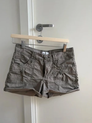 Y2K 2000s mini cargo shorts - Säljer ett par supercoola cargo shorts med 2000-talskänsla. Låg midja, ganska korta och cargofickor. De är lite försmå för mig som man kan se på bilden också 😅  Längd = 30cm Bredd = 40cm