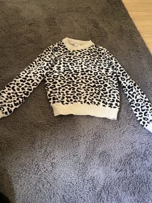 Leopardmönstrad stickad tröja  - Säljer en snygg stickad tröja från JDY med leopardmönster i svart och vitt. 