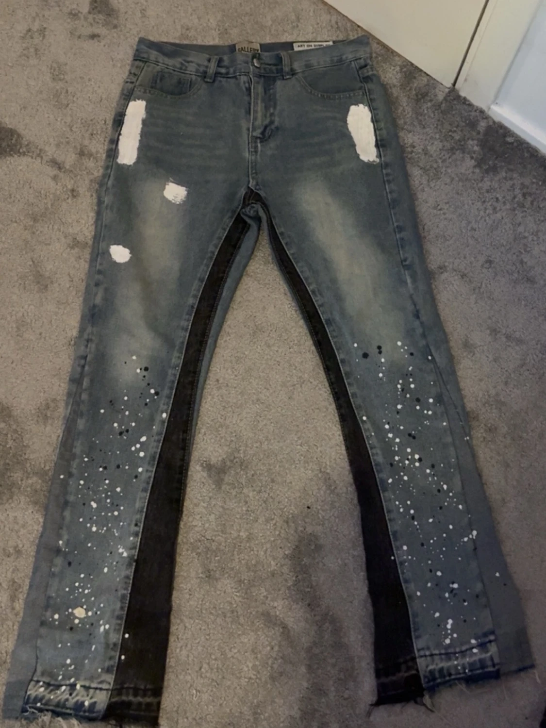 Grå jeans med färgstänk och slitningar