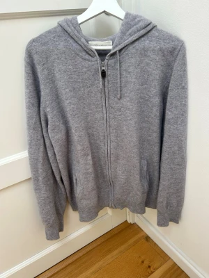 Grå kashmirhoodie med zip - Säljer denna gråa kashmirhoodie med full zip. Tröjan är av 100% Kashmir och sparsamt använd utan synbara defekter. Hör gärna av er vid frågor!