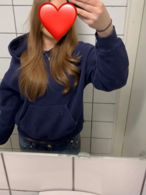 Mörkblå hoodie med huva - En basic mörkblå hoodie med huva. Hoodien har ribbade muddar vid ärmslut och nederkant. Perfekt för en avslappnad och chill stil. Materialet är mjukt och bekvämt mot huden.