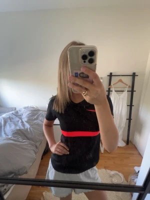 Svart Nike sporttröja med röd detalj - Helt nytt skick!  Jag står inte för frakt, tar gärna emot bud under det satta priset för kompromiss!💗   Allt jag säljer är i stort sätt i nytt skick för ett lägre pris, kolla in resten av mina artiklar i min profil!