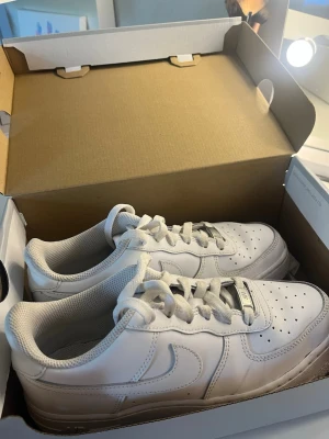 Vita Nike Air Force 1 sneakers - Klassiska vita Nike Air Force 1 sneakers som knappt är använda. De är lite smutsiga på undersidan av skorna och några små märken på sidorna, som går att få bort. Orginal lådan är kvar. Jätte sköna att gå i och passar till allt🥰