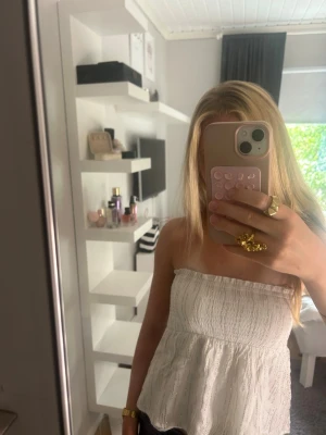 Vit tubtopp med guld glitter - Säljer en vit bandeau tubtopp, fungerar även som en kjol, glittret har även gått av lite men jättefin ändå!❤️